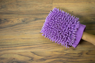 Hand wear violet fabric hand wash glove on wood table background