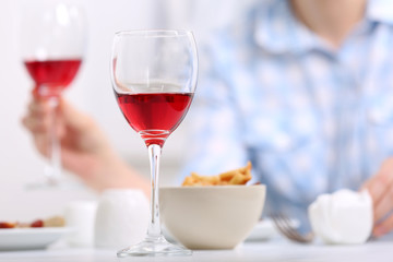 Dinner with glasses of wine on light blurred background