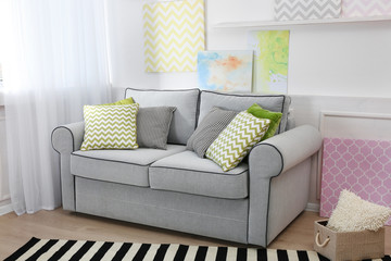 Modern interior with sofa and pictures on shelves in room