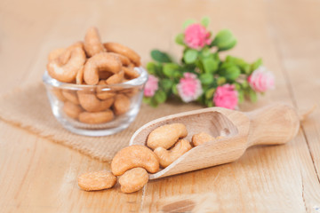Cashew nuts in spoon, on the wooden
