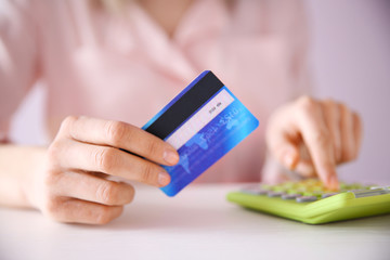 Female calculate with credit card, closeup