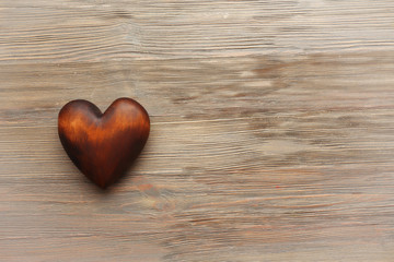 Obraz premium Brown heart on wooden background