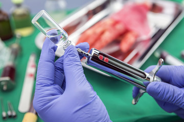 Nurse filling syringe with medication in a room of operating the
