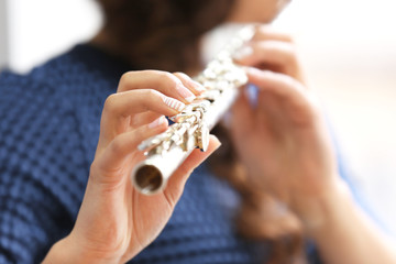 Woman playing on flute closeup