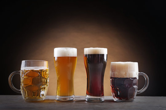 Different sorts of draft beer in glasses on wooden table