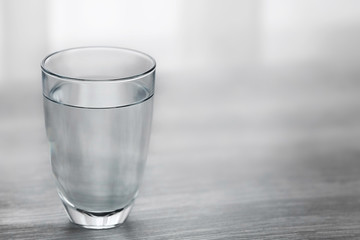 Glass of water on wooden background