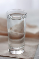 Glass of water with napkin  on wooden background
