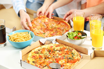 Happy family hands eating pizza.