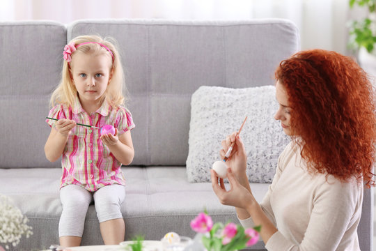 Mother and daughter decorating Easter eggs, indoors