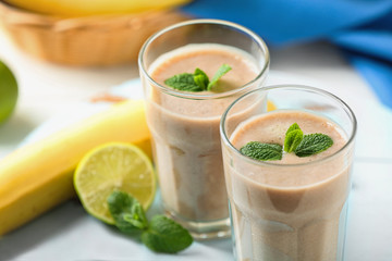 Banana cocktail and fresh fruits on wooden table