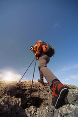 Young man with backpack on a mountain top on a sunny day.