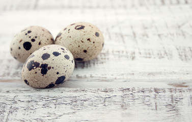 Quail eggs on rustic wooden background. Soft view.