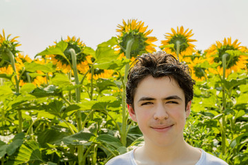boy smiling in front of sunflower field