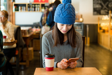 Woman use of mobile phone at coffee shop