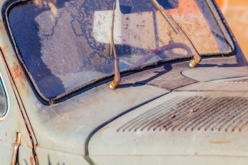 carcass of an old rusty car in the desert