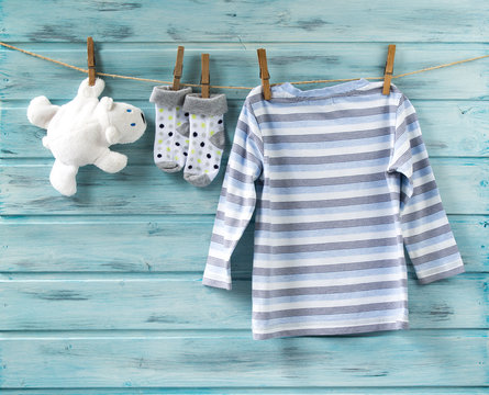 Baby boy shirt, socks and white toy bear on a clothesline