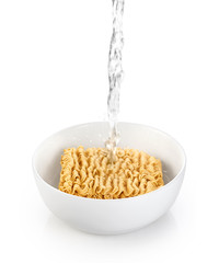 Cooking instant noodles, pouring boiling water.