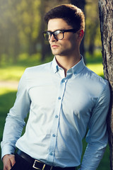 Closeup young handsome man wearing classes in the park