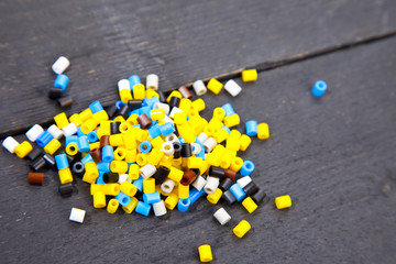 Colorful iron beads on dark black wooden background