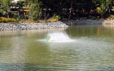 Fototapeta na wymiar PADDLE WHEEL AERATOR with water splash is working in pool