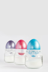 Colored easter eggs in white egg cups. Top view with copy space.