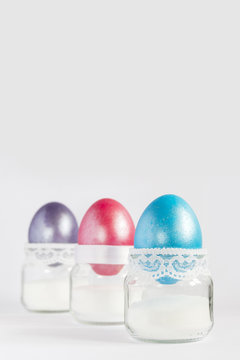 Colored easter eggs in white egg cups. Top view with copy space.
