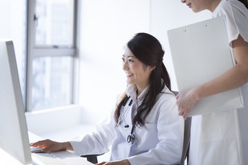 Female doctors and nurses are looking at the screen of a personal computer