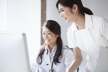 Doctors and nurses are looking at the screen of a personal computer