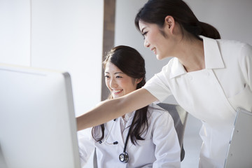 Doctors and nurses are looking at the screen of a personal computer