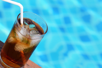 A glass of ice cola at pool with vintage filter background