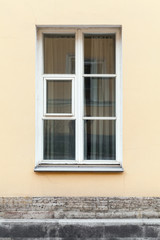 Fototapeta na wymiar Yellow wall and window in white frame