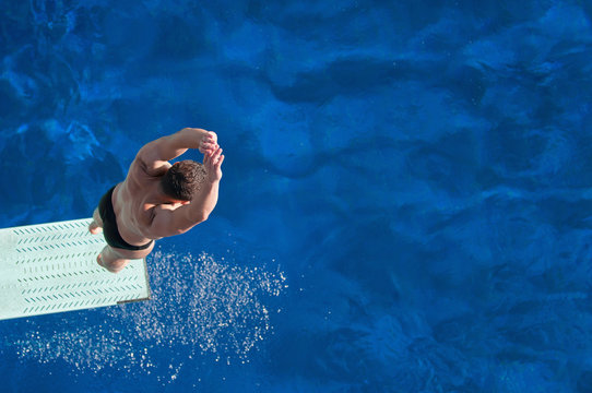 Springboard diving. Male diver bouncing on the springboard before the jump