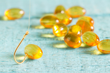 Omega 3 pill on fishing hook abstract diet concept
