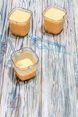 Three jars of yogurt stands on the aged boards