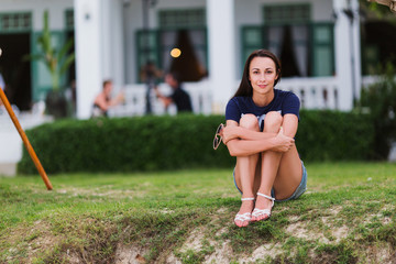 Fototapeta premium Young girl sitting on the grass, evening, summer, holiday