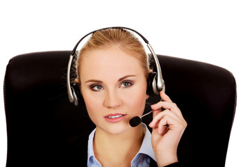 Young woman helpline operator is trying to hear something headphones