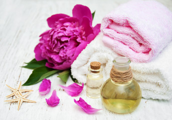 Obraz na płótnie Canvas Peony flowers, massage oils and towels