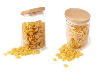 Set of glass jar filled with dry conchiglie pasta over isolated white background