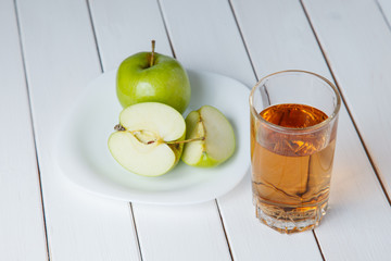 Apple juice from green apples on a white wooden background
