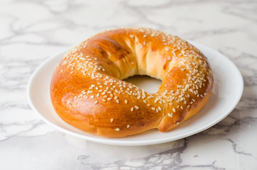 Bagels in white plate on marble background
