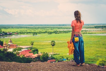 Naklejka premium Woman standing on top of a hill enjoying Floating village view, Phnom Krom, Siem Reap, Cambodia
