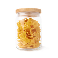 Glass jar filled with dry farfalle pasta over isolated white background