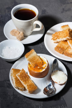 soft boiled egg, toasts and cup of coffee for breakfast