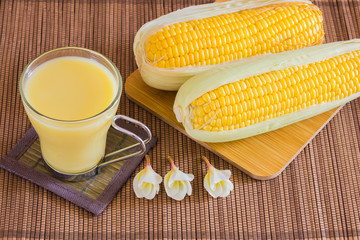 Corn milk in glass, kernel corn in bowl and fresh corn