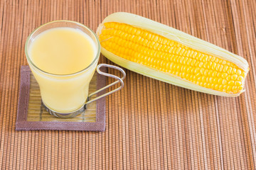 Corn milk in glass, kernel corn in bowl and fresh corn