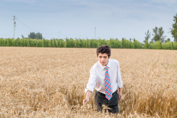 Naklejka na ściany i meble Cute boy in a golden wheat field