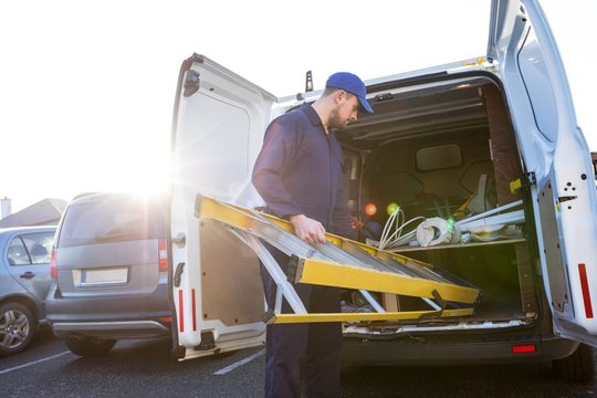Handyman loading a ladder 