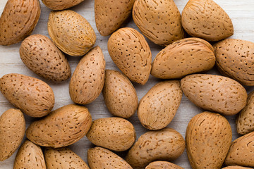 Group of almond nuts with leaves.Wooden background.