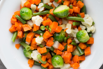 Fresh vegetables mix in a white bowl.
