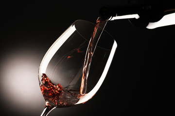 glass with red wine on dark background